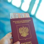 Russian passport held in hand with boarding pass peeking out, ready for travel.
