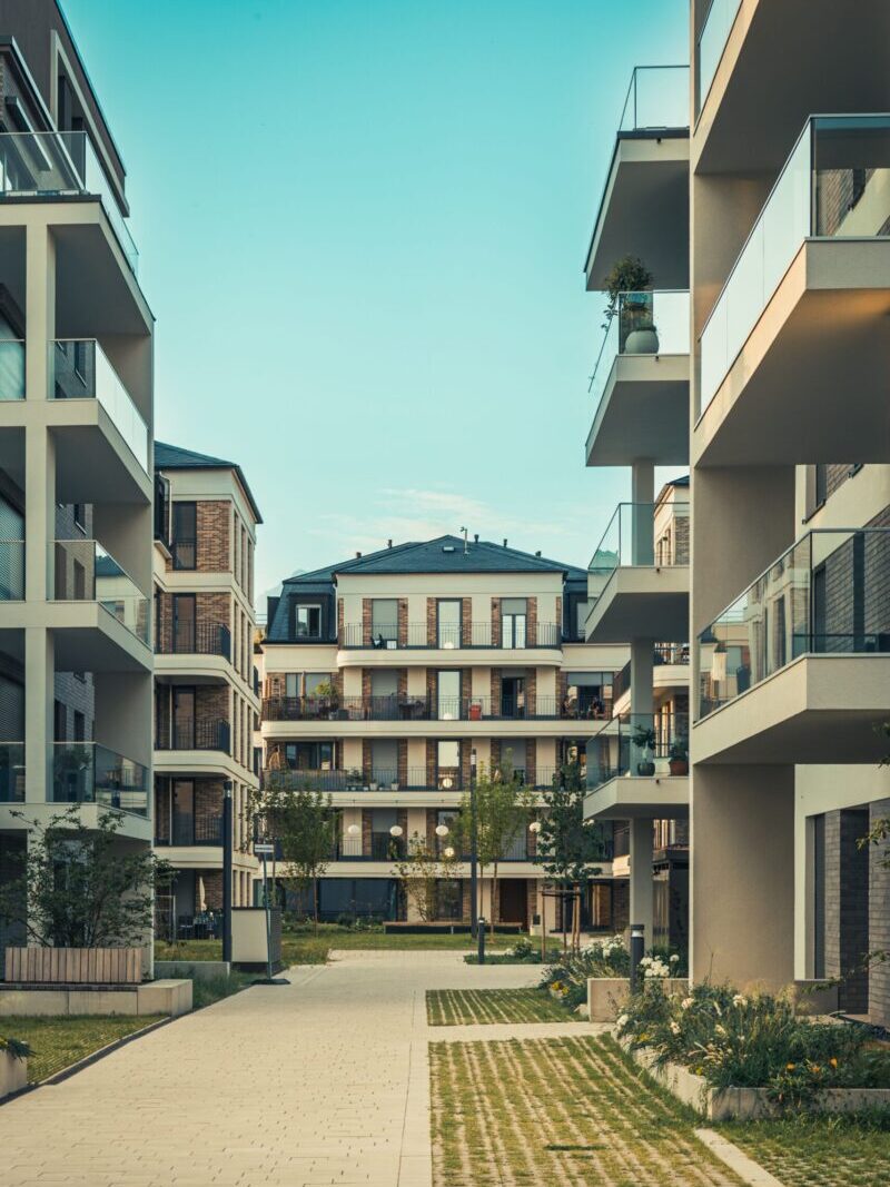 Contemporary cityscape featuring luxury apartments with balconies and outdoor pathways.